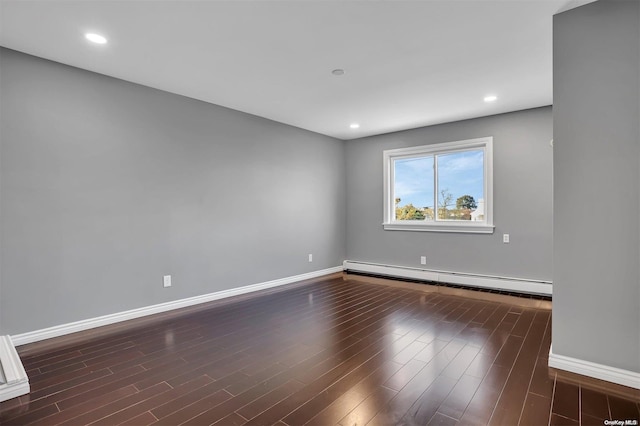 empty room with dark wood-type flooring and a baseboard radiator