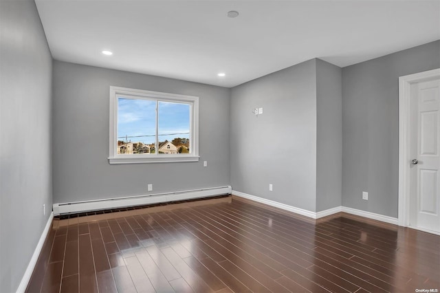 empty room featuring dark hardwood / wood-style floors and baseboard heating