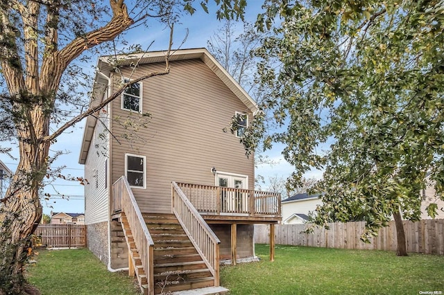 back of house featuring a lawn and a wooden deck