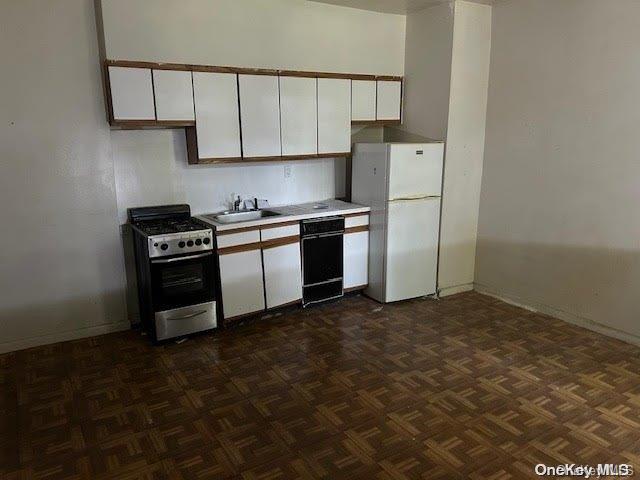 kitchen with gas range, sink, dishwasher, white cabinets, and white fridge