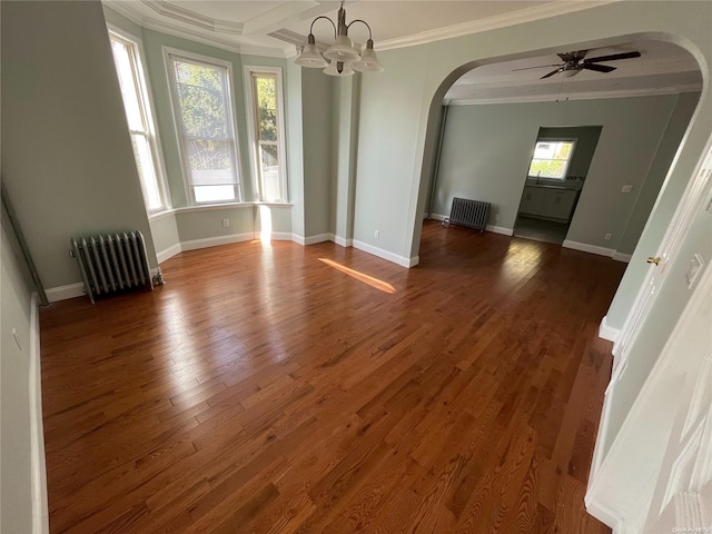 spare room with dark hardwood / wood-style floors, plenty of natural light, radiator, and crown molding