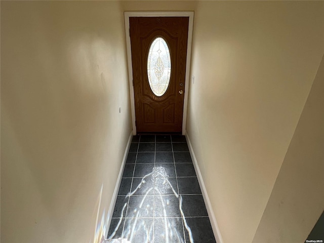 doorway featuring dark tile patterned flooring