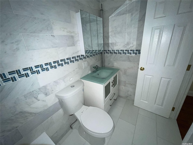 bathroom with backsplash, tile patterned flooring, vanity, and tile walls