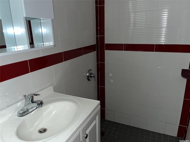 bathroom with tile patterned flooring, vanity, and tile walls