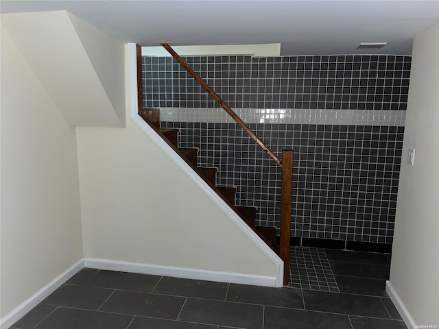 stairs with tile patterned floors and tile walls