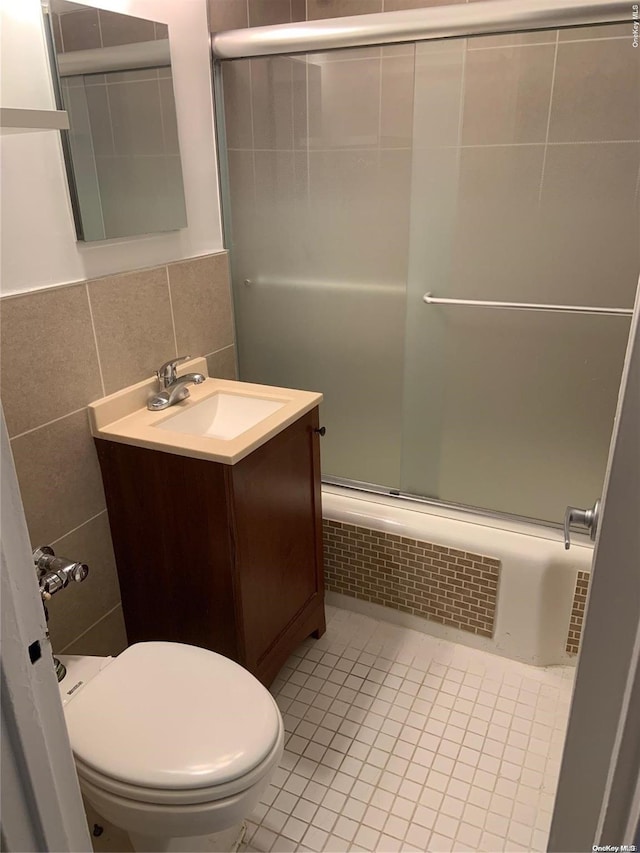 full bathroom with backsplash, vanity, tile walls, enclosed tub / shower combo, and toilet