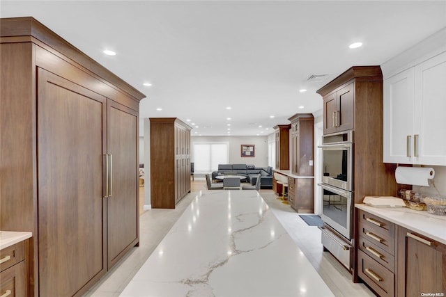 kitchen with double oven and light stone countertops