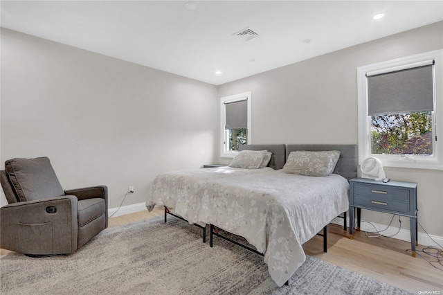 bedroom with light wood-type flooring and multiple windows