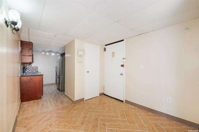 interior space featuring a drop ceiling and parquet floors