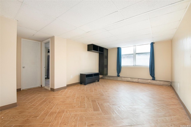 spare room featuring a paneled ceiling and light parquet floors