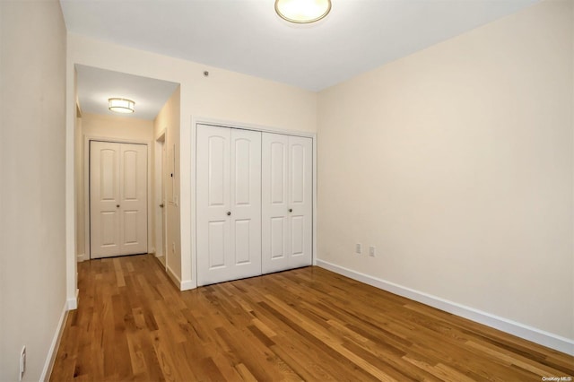 unfurnished bedroom featuring wood-type flooring and a closet