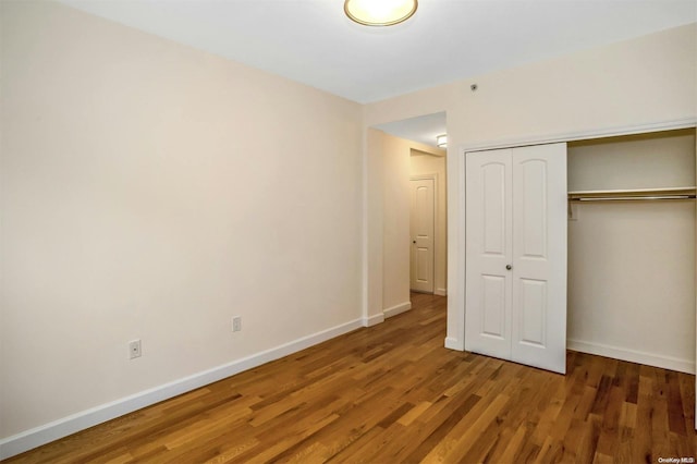 unfurnished bedroom with hardwood / wood-style floors and a closet