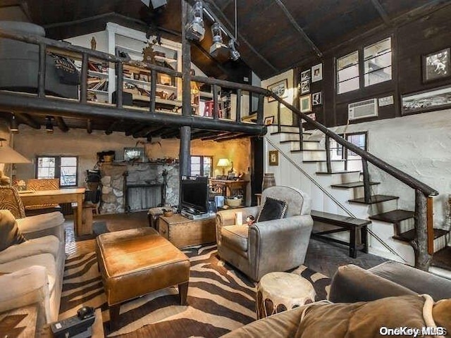 living room with a stone fireplace and lofted ceiling