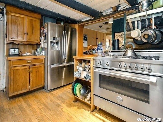 kitchen with beamed ceiling, wood ceiling, appliances with stainless steel finishes, and light hardwood / wood-style flooring