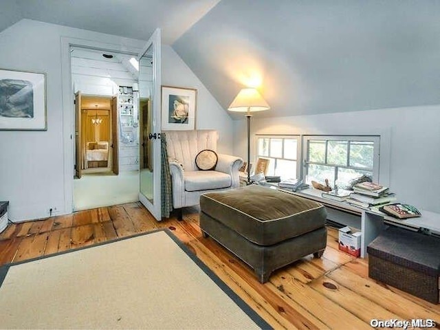 sitting room with wood-type flooring and lofted ceiling