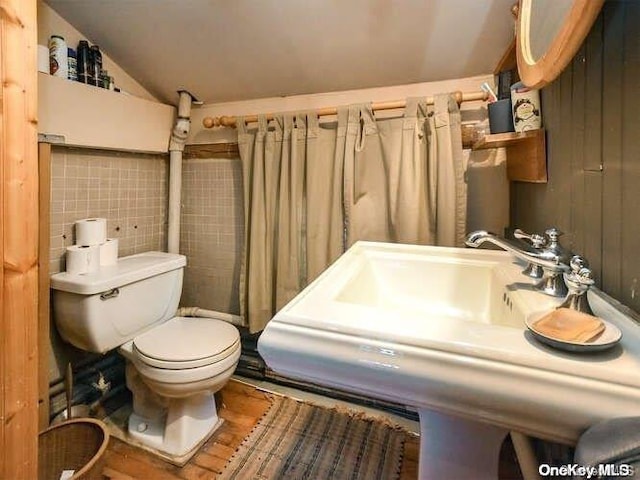 143 Piping Rock Rd, Locust Valley, NY 11560 - bathroom featuring toilet, vaulted ceiling, tile walls, and a sink