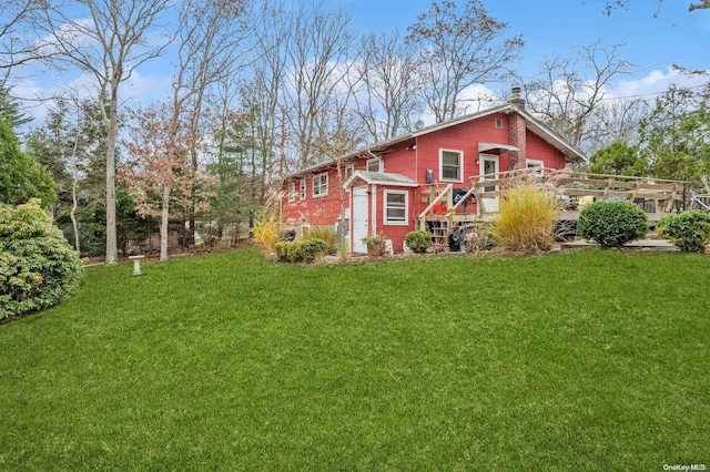 back of house with a deck and a lawn