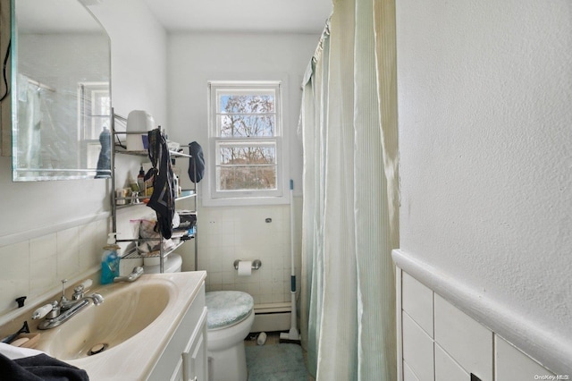 bathroom with vanity, toilet, tile walls, and a baseboard heating unit