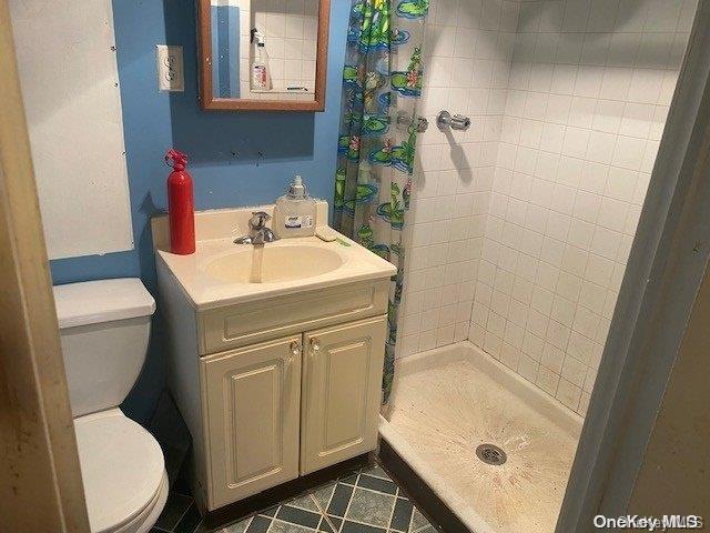 bathroom with a shower with curtain, toilet, and vanity