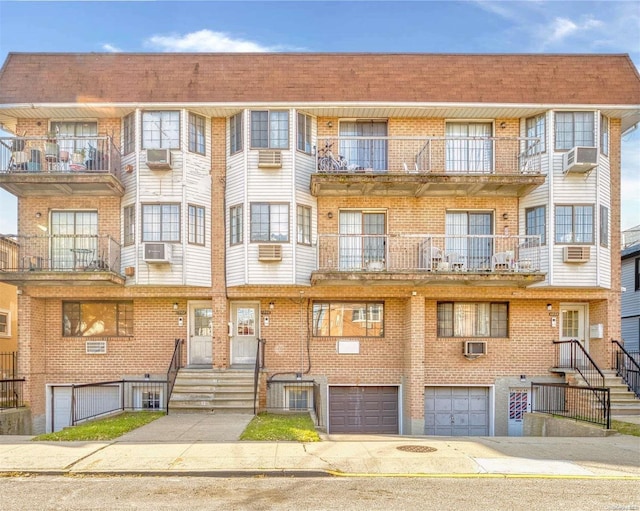 view of property featuring a wall unit AC, cooling unit, and a garage