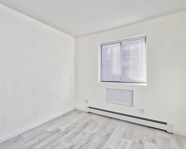 unfurnished room with light hardwood / wood-style flooring and a baseboard heating unit