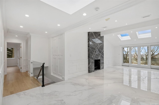 hallway featuring light wood-type flooring, a skylight, and crown molding