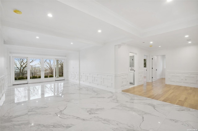 unfurnished room with beamed ceiling, ornamental molding, and light hardwood / wood-style flooring