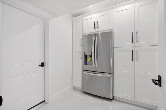 kitchen with stainless steel fridge and white cabinetry