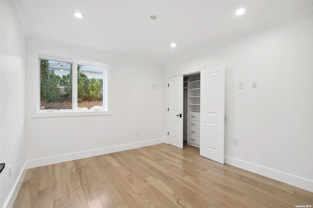 unfurnished bedroom featuring light wood-type flooring, a closet, and ornamental molding