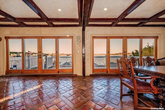 interior space featuring coffered ceiling, plenty of natural light, and french doors