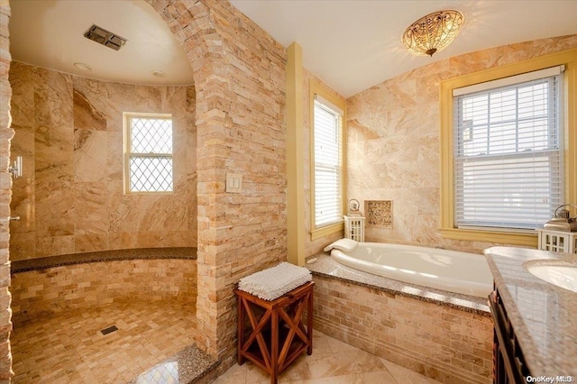 bathroom featuring vanity, tile walls, and tiled tub