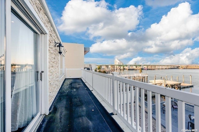 balcony featuring a water view and a boat dock