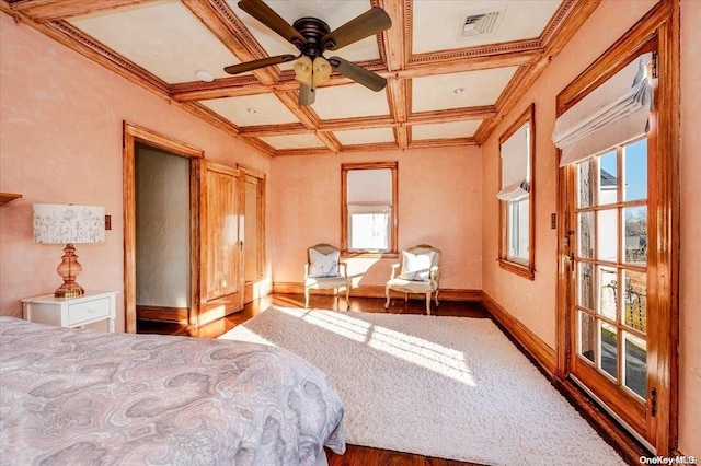 bedroom featuring ornamental molding, coffered ceiling, ceiling fan, hardwood / wood-style flooring, and beamed ceiling