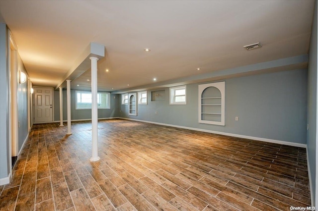 basement featuring built in shelves and dark hardwood / wood-style flooring