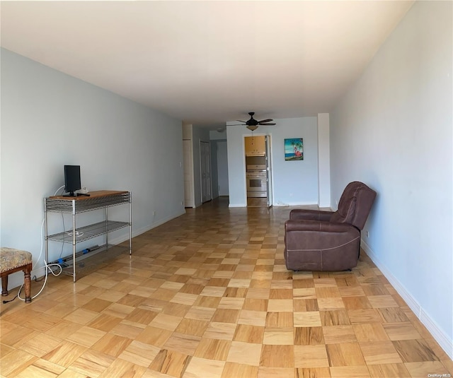 living area with light parquet flooring and ceiling fan