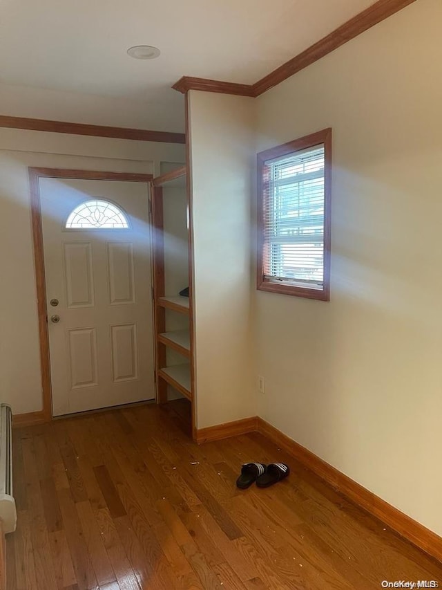 foyer with light hardwood / wood-style floors and ornamental molding