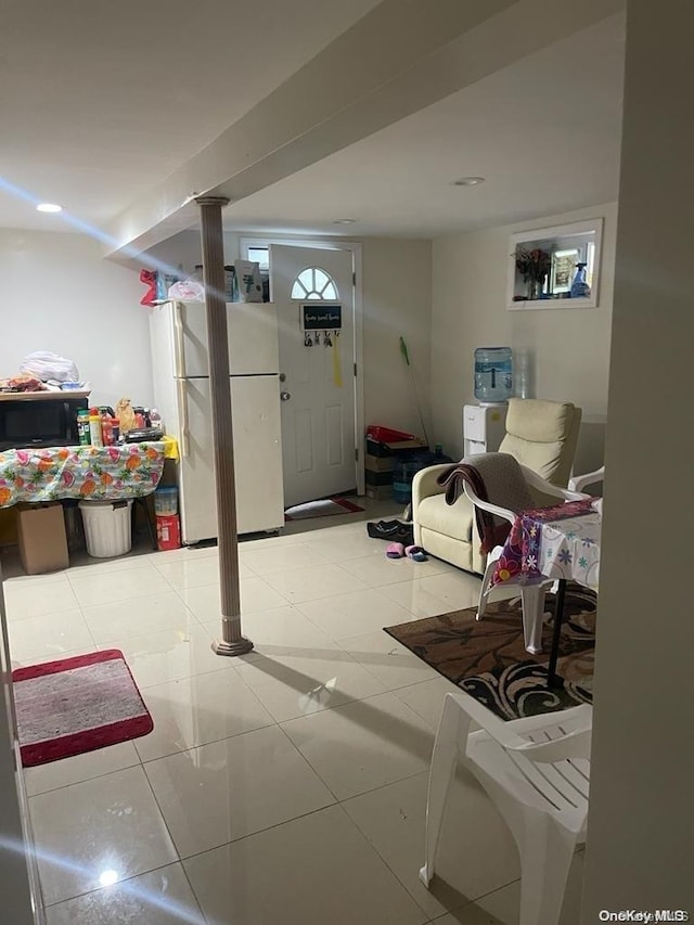 basement with white fridge and light tile patterned floors