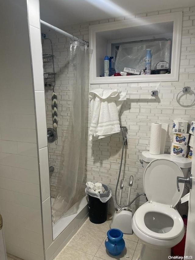 bathroom with a shower with curtain, tile patterned flooring, and toilet