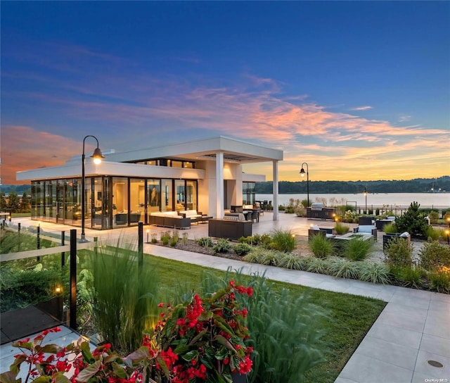 exterior space with outdoor lounge area, a water view, and a patio