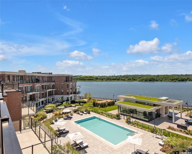 view of swimming pool with a patio area and a water view