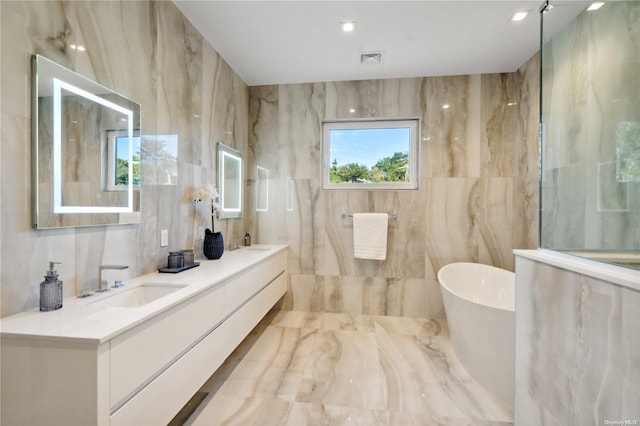 bathroom with vanity, a tub to relax in, and tile walls