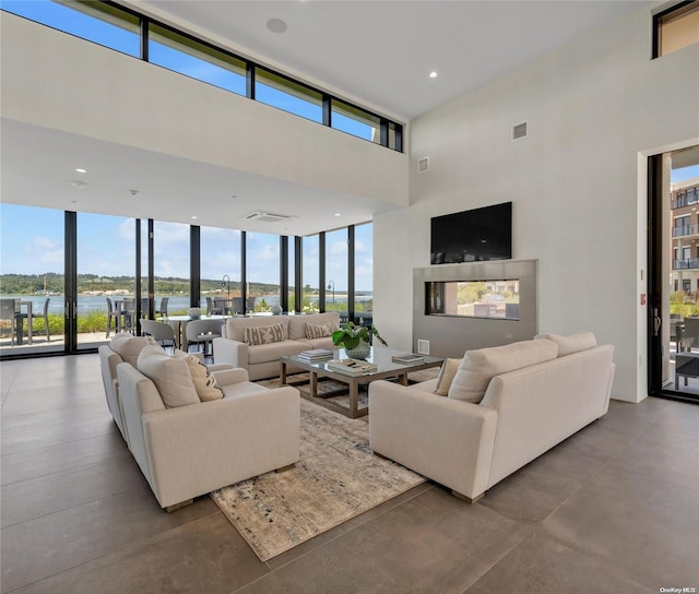 living room featuring plenty of natural light, a water view, and concrete flooring