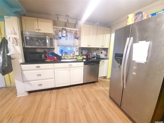 kitchen featuring ornamental molding, light hardwood / wood-style floors, plenty of natural light, and appliances with stainless steel finishes