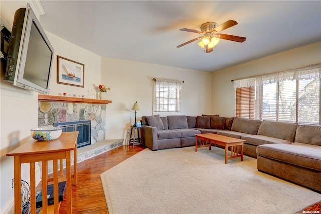 living room with a fireplace, crown molding, hardwood / wood-style floors, and ceiling fan