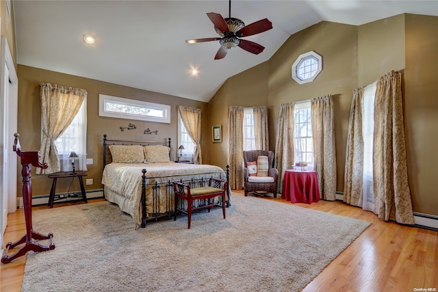 bedroom with ceiling fan, light hardwood / wood-style floors, high vaulted ceiling, and a baseboard heating unit