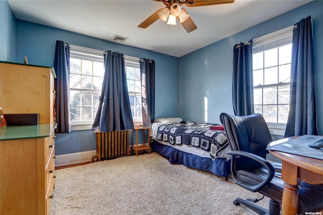 bedroom with radiator heating unit, carpet floors, and ceiling fan