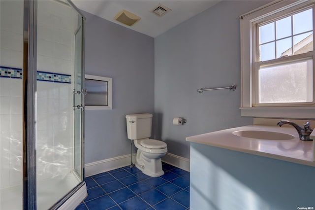 bathroom featuring tile patterned floors, vanity, toilet, and a shower with shower door