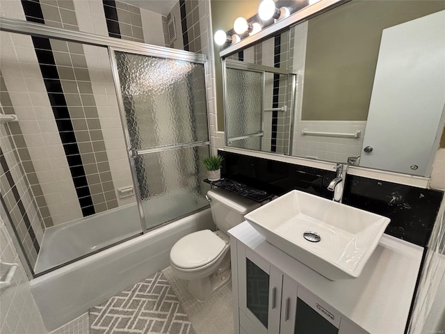 full bathroom with shower / bath combination with glass door, toilet, vanity, and tile patterned flooring