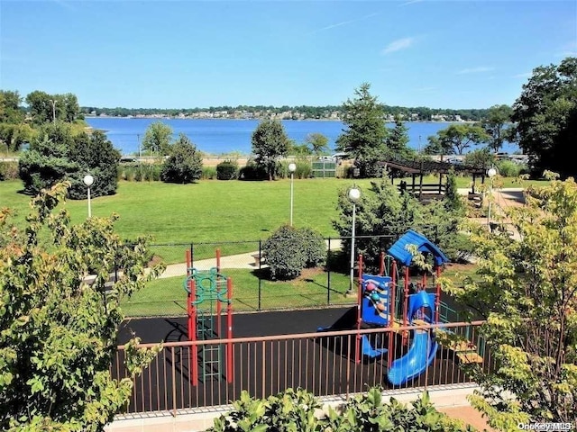 view of playground with a yard and a water view