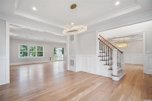 interior space featuring an inviting chandelier, ornamental molding, and light wood-type flooring